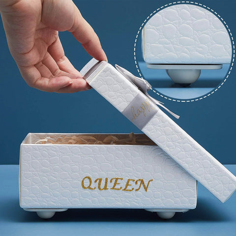 White box with lid reading 'QUEEN' and embossed texture, hand lifting lid to reveal interior, designed with decorative purposes.