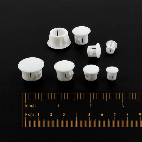 "Assorted White Plastic Hole Plugs Set Of Four Sizes One Quarter Inch Five Sixteenths Inch Three Eighths Inch One Half Inch No Fuss Flush Snap In Locking Caps For Furniture Post Tubes 200 Count with ruler on black background"