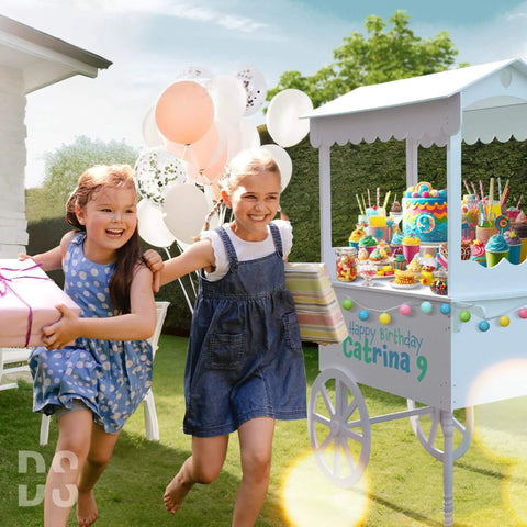 Outdoor party with children near a candy cart on wheels for parties with 40 balloons included, featuring desserts and decorations.