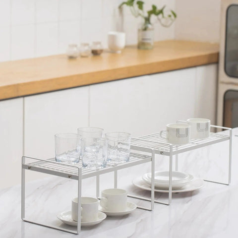 Two Pack Steel Frame Stackable Cabinet Shelf Organizer Racks For Kitchen Pantry Bathroom Bedroom And Office Space Saving Counter Desk Storage Rust Resistant Non Slip White Ideal For Cabinets And Drawers Versatile Home Organization In White Finish with cups and glasses
