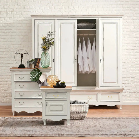 White wooden dresser and wardrobe in room with plants and decor