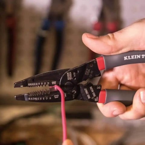 Person using Kurve Wire Stripper Crimper Cutter Multi Tool for 10-26 AWG solid and 12-28 AWG stranded wire in a workshop.
