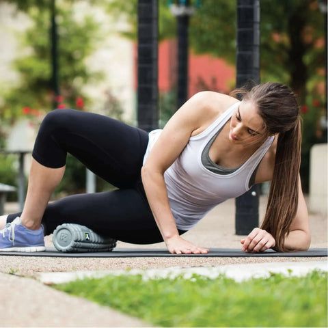 Woman using 12 Inch Foam Massage Roller With Softer Compression For Back, Body And Legs, Deep Tissue Recovery in outdoor setting