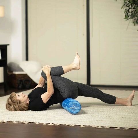Person using Pro Roller Soft Density EVA Foam Roller For Physical Therapy Pilates Yoga And Muscle Recovery 36 Inch Blue for stretching.