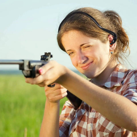 Woman at shooting range wearing Orange Banded Silicone Ear Plugs for Shooting Range and Noise Reduction with Lightweight Plastic Banding