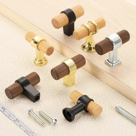 Assorted beech wood and metal T-bar drawer pulls on beige fabric, highlighting various finishes and styles. Includes screws and ruler for scale.