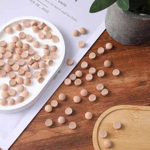 Flat Head Wood Plugs Set, 100 Pcs Three Eighths Inch Screw Hole Plugs scattered on wood surface and tray