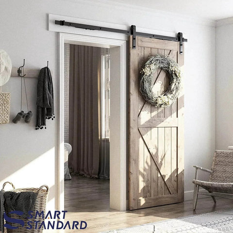 6.6 FT Sliding Barn Door Soft Close Hardware Kit installed on a wooden door with wreath, showcasing J Shape design, smoothly and quietly.