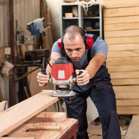 Woodworker uses router in workshop; ideal for Five Sixteenth Inch Internal Threaded Clamping Knobs for precise routing setups