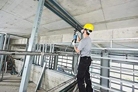 Worker using One And One Eighth Inch SDS-Plus Bulldog Xtreme Max Rotary Hammer for concrete drilling in a construction site.