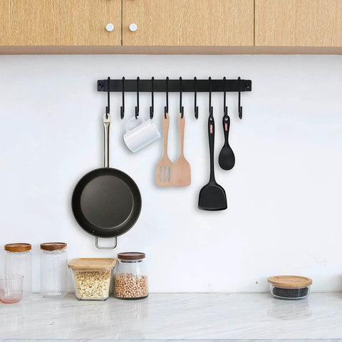 Wrought Iron Kitchen Holder: 10-Hook Wall-Mounted Utensil Rack with Black Finish holding pan, mug, and utensils