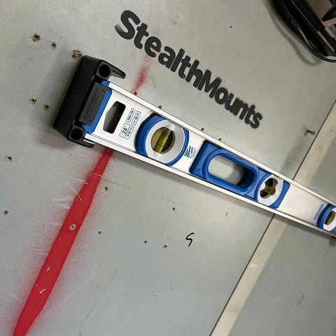 Yellow Universal Level Holder With Locking Mounts For All Levels In A 2 Pack Fits All Brands And Surfaces Ready For Secure Level Storage And Hassle Free Transport StealthMounts Built For Everyday Use No Brainer Setup holding a level on wall