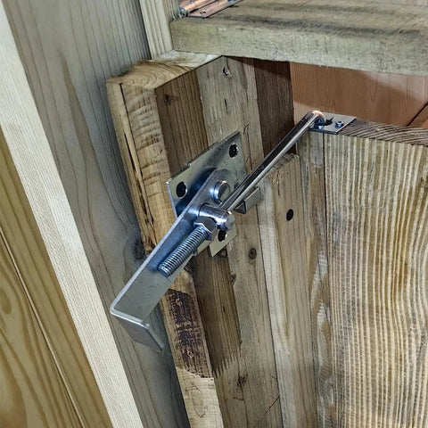 Zinc Barn Door Jamb Latch With Hook 7 Inch Cam Latch installed on a wooden sliding door, showing adjustable latch mechanism.